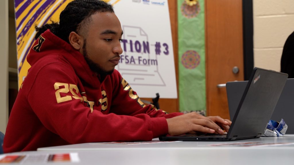Miqueas Soriano completes his online Free Application for Federal Student Aid with the help of College Bound volunteers at Creekside High School.