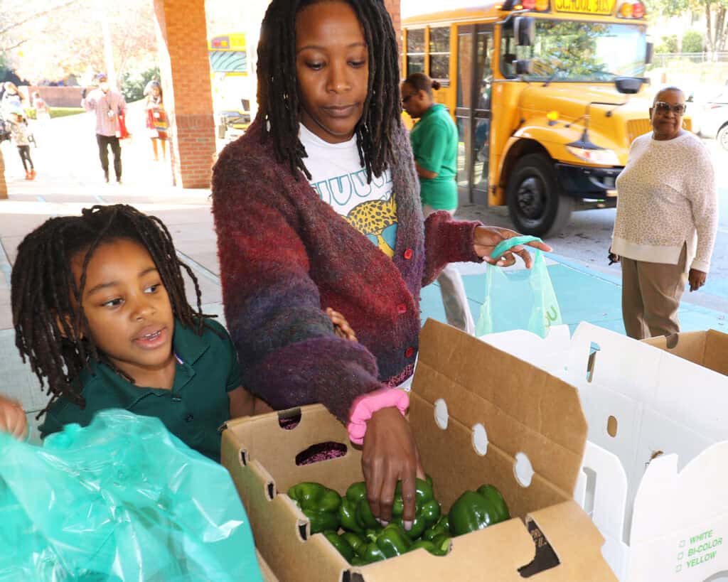 Families shop at the free produce market, hosted at Title 1 schools to combat the SNAP gap and food insecurity.