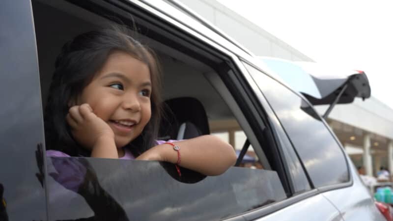 At-risk child receiving food stability services in a car