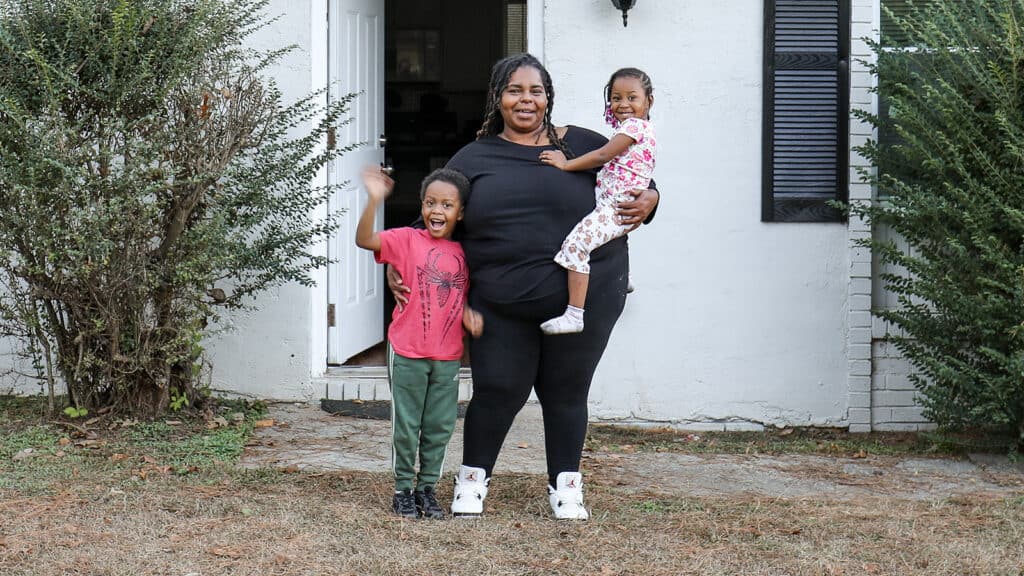 With support from United Way of Greater Atlanta’s Kids Home Initiative, Taquana overcame housing instability and stands in front of her home with her family.